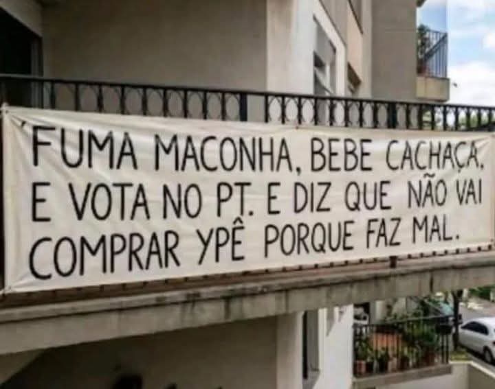 Uma faixa pendurada na sacada de um apartamento es